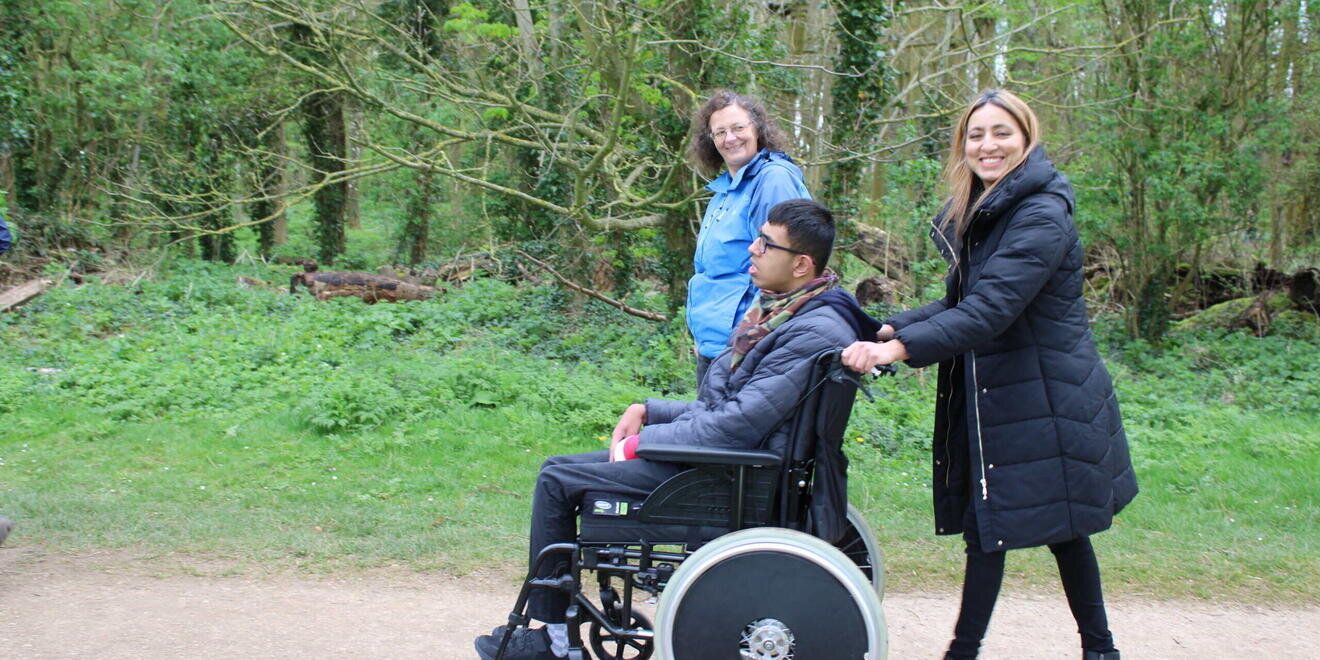woman walking with her son in a wheelchair